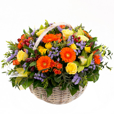 cesta con flores variadas en tonos cálidos